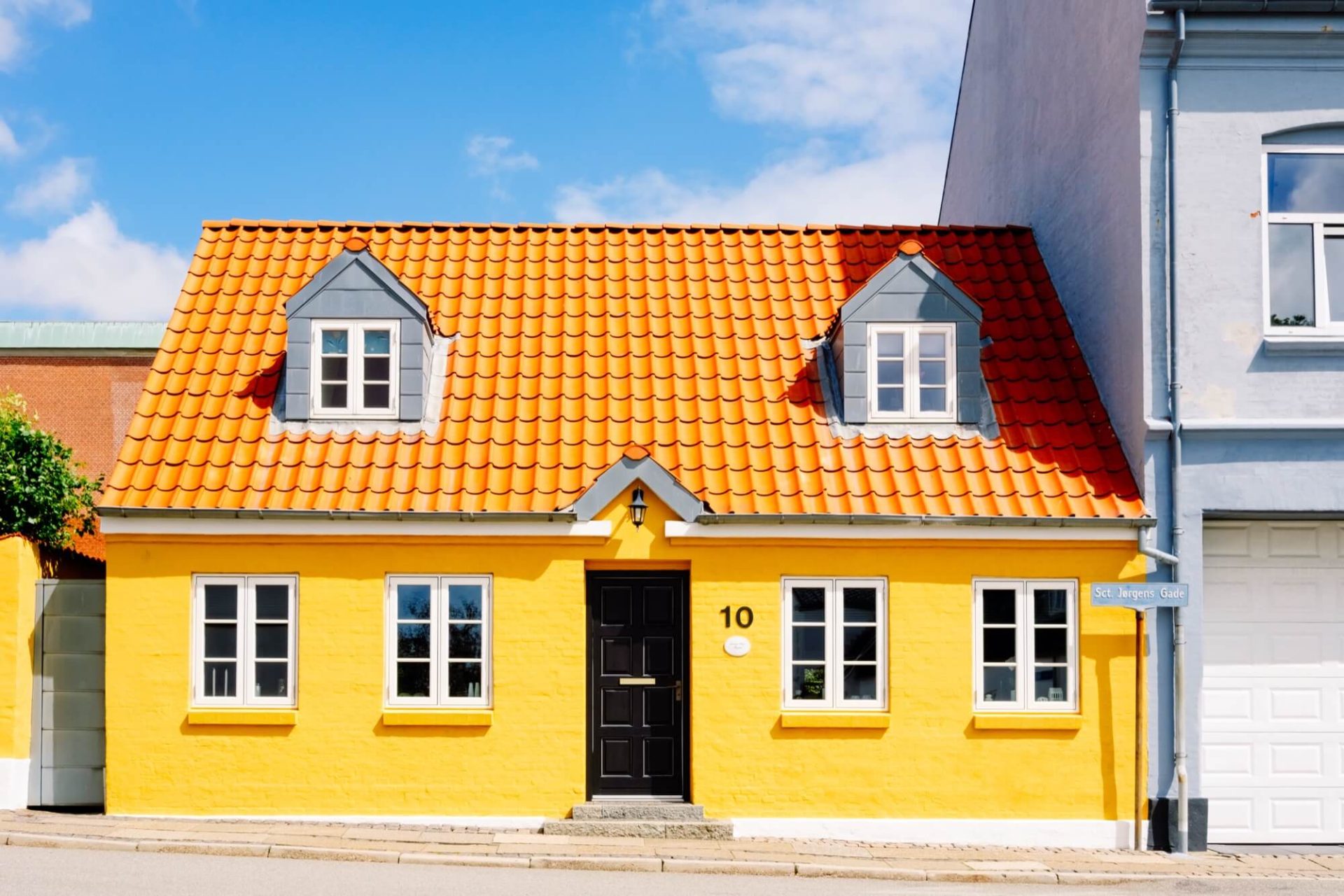 Detta gula hus med sitt karakteristiska orangea tak och svarta dörrar är en del av stadens landskap